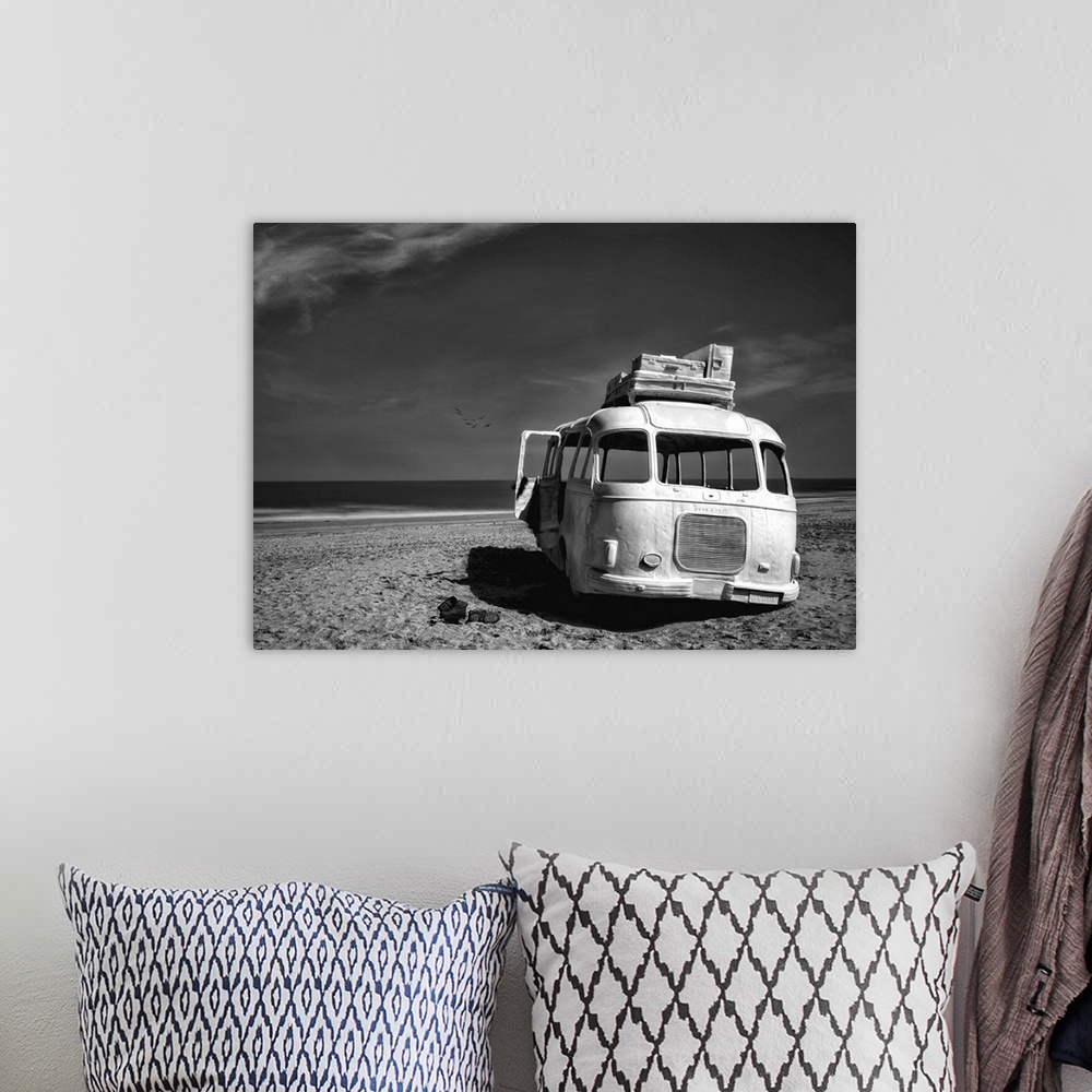 A bohemian room featuring Black and white image of an abandoned bus with windows missing on a sandy beach in Belgium.