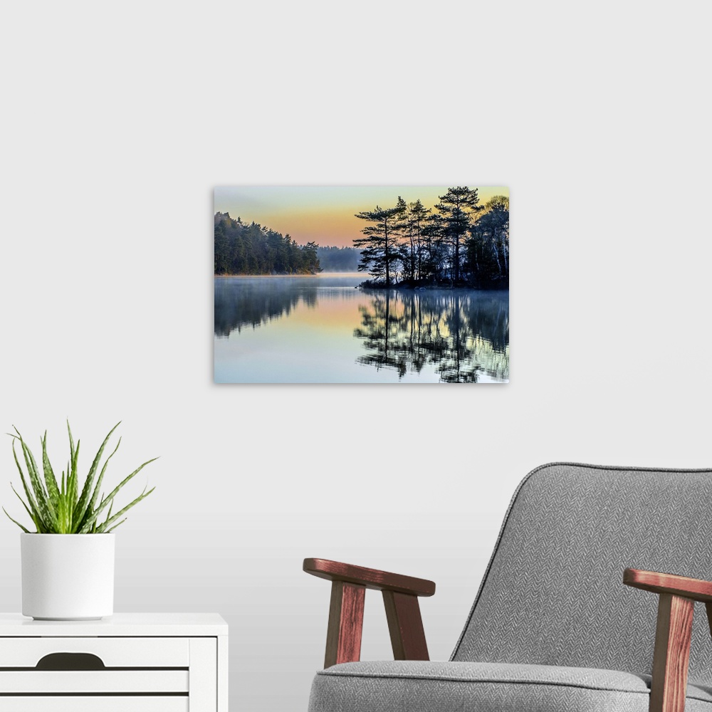 A modern room featuring Pastel rainbow sky over a lake in the early morning in Sweden.