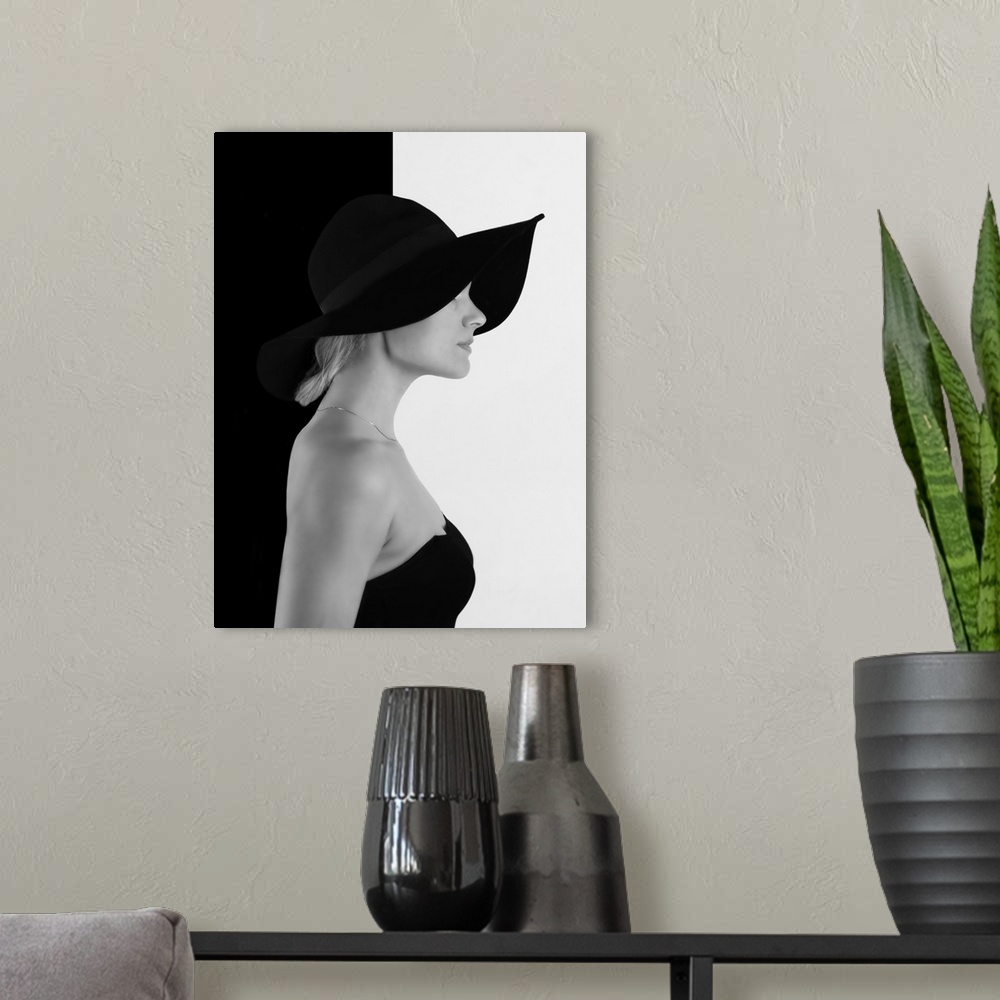 A modern room featuring Portrait of a woman with a black hat, against a half black, half white wall.
