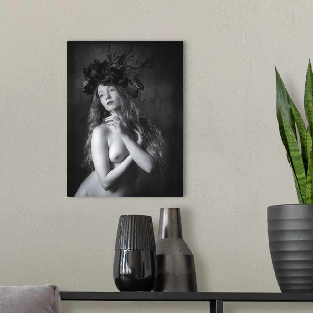 A modern room featuring Black and white fine art portrait of a nude woman wearing a floral and butterfly headpiece.