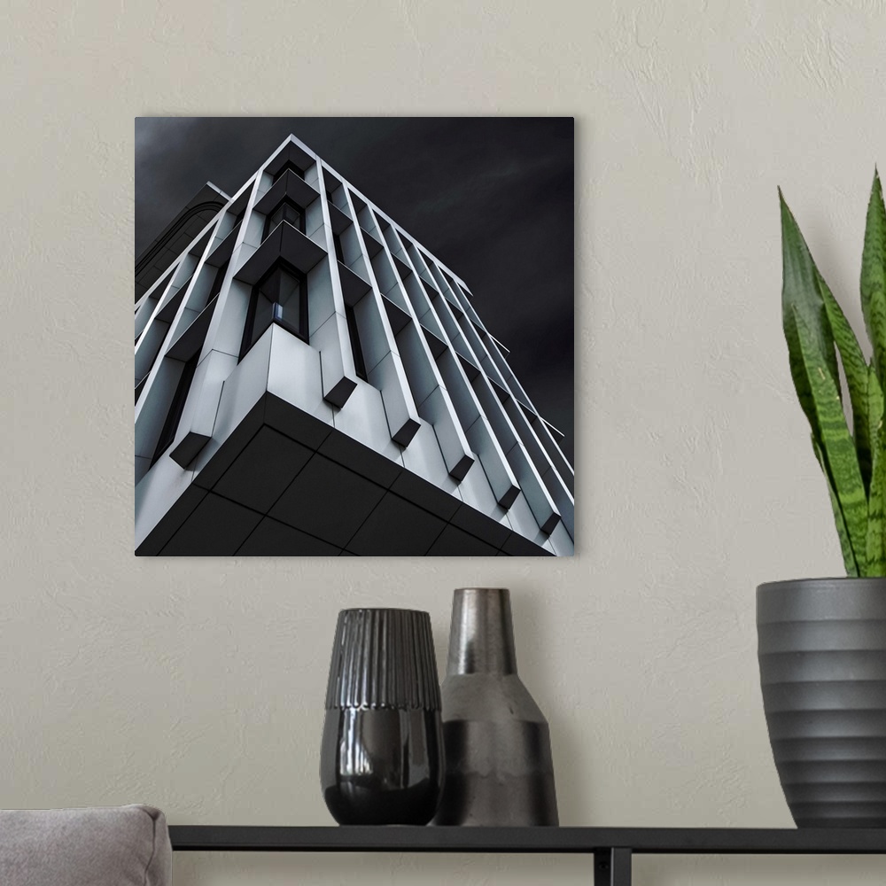 A modern room featuring Square abstract black and white photograph with a blue tint looking up at a modern building.