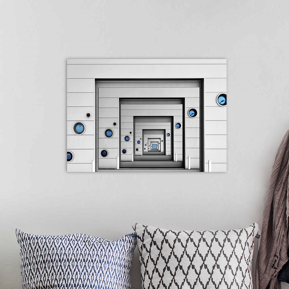 A bohemian room featuring Conceptual image of a wall with blue portholes infinitely repeating itself.