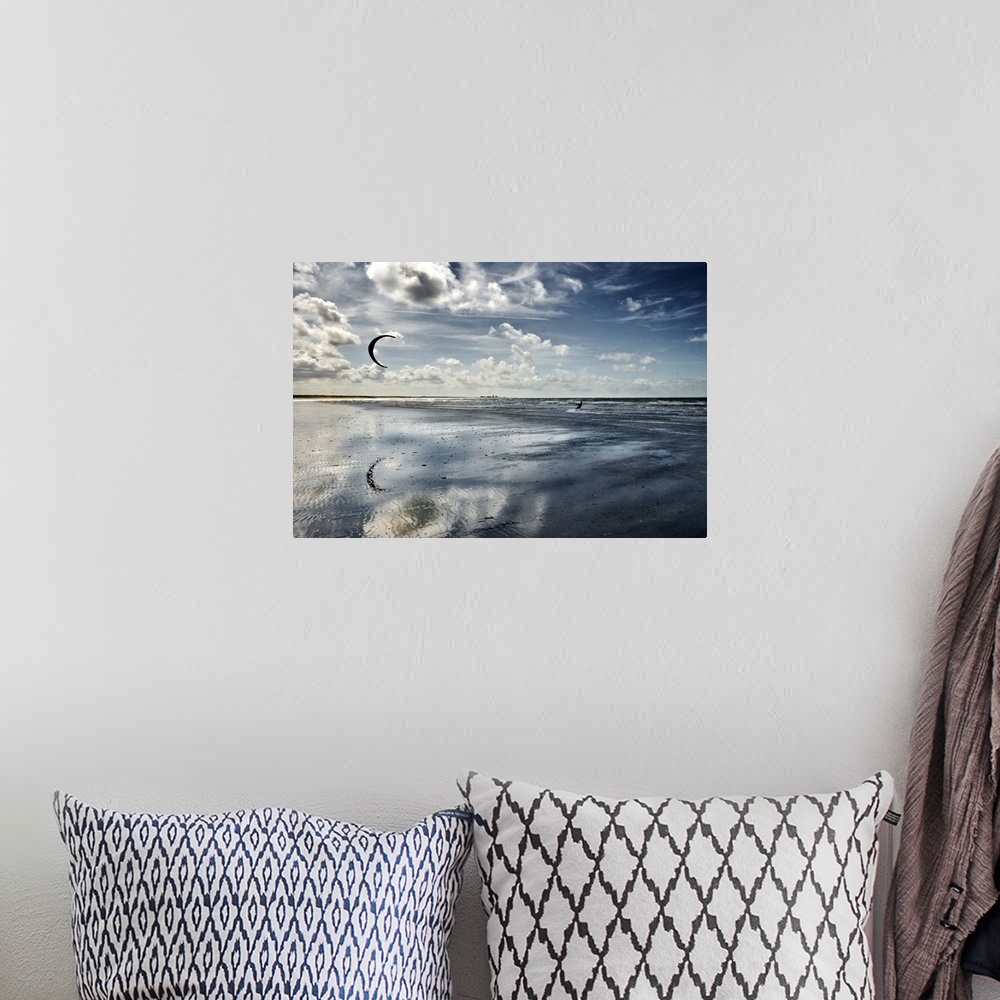 A bohemian room featuring Cool toned photograph of a silhouette of a person kite boarding in the ocean on a beautiful day.