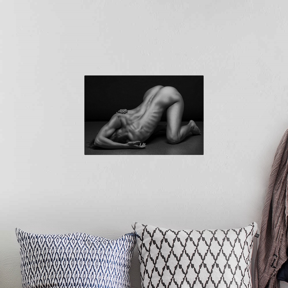 A bohemian room featuring Black and white fine art photograph of a nude woman creating angles and shapes with her body.