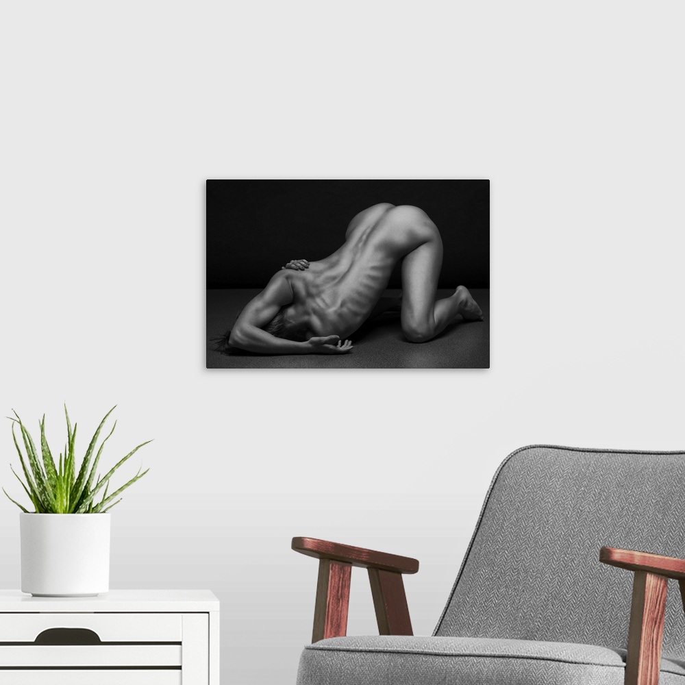 A modern room featuring Black and white fine art photograph of a nude woman creating angles and shapes with her body.