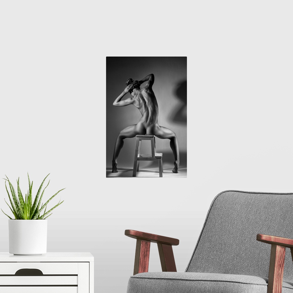 A modern room featuring Black and white fine art photograph of a woman with her back to us, sitting in a chair and creati...