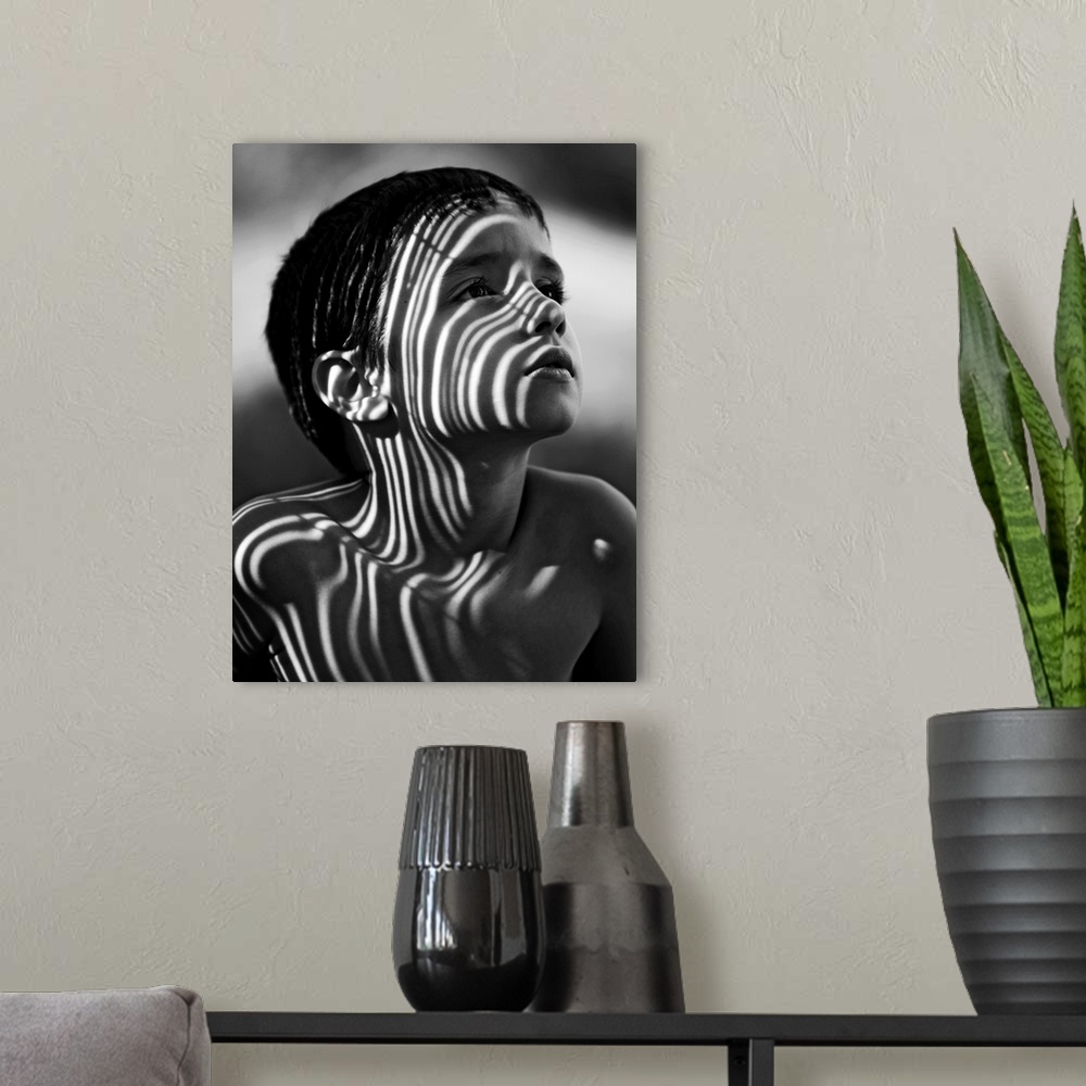A modern room featuring Portrait of a young boy with striped shadows across his face.