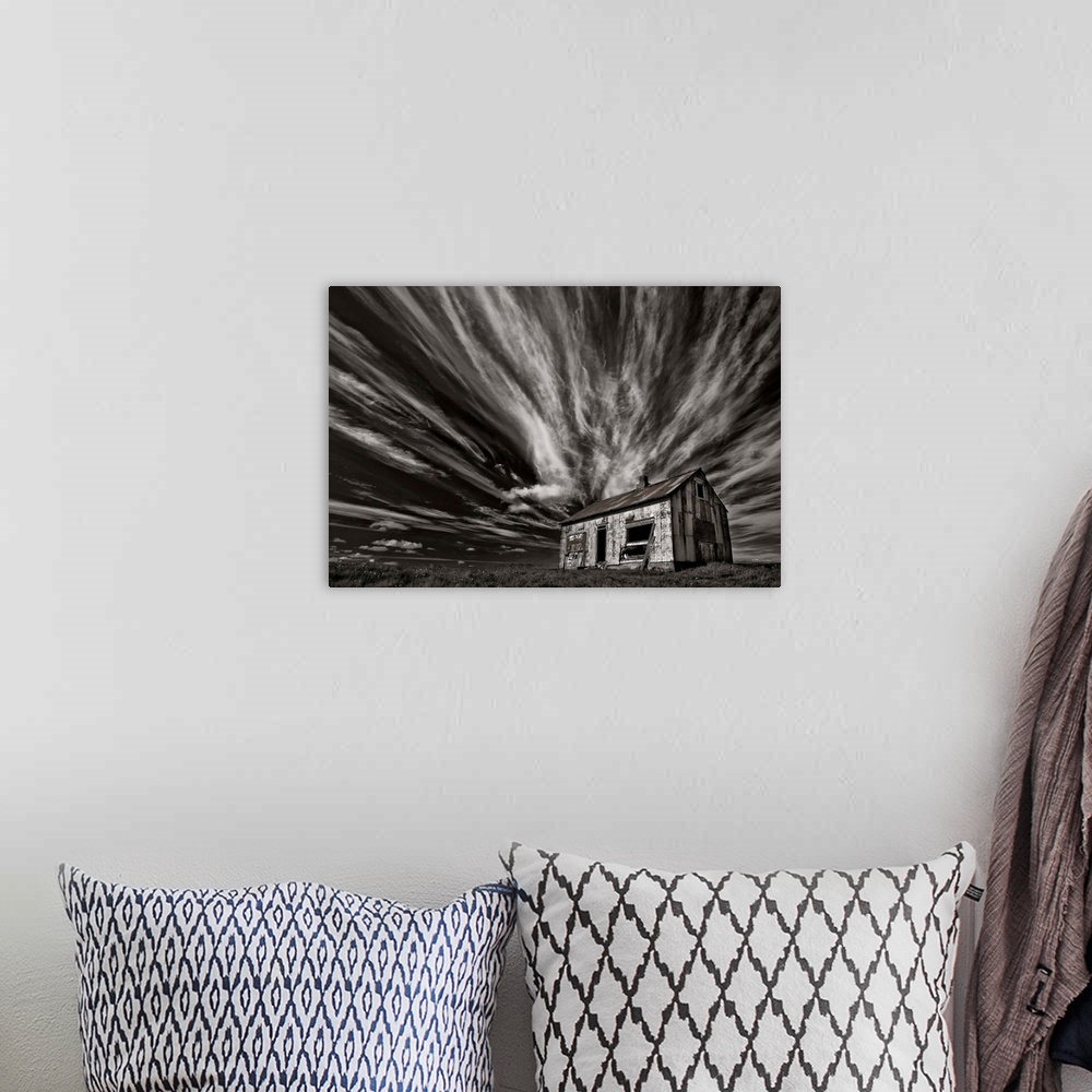 A bohemian room featuring High contrast photo of a cabin in Iceland with clouds streaking overhead.