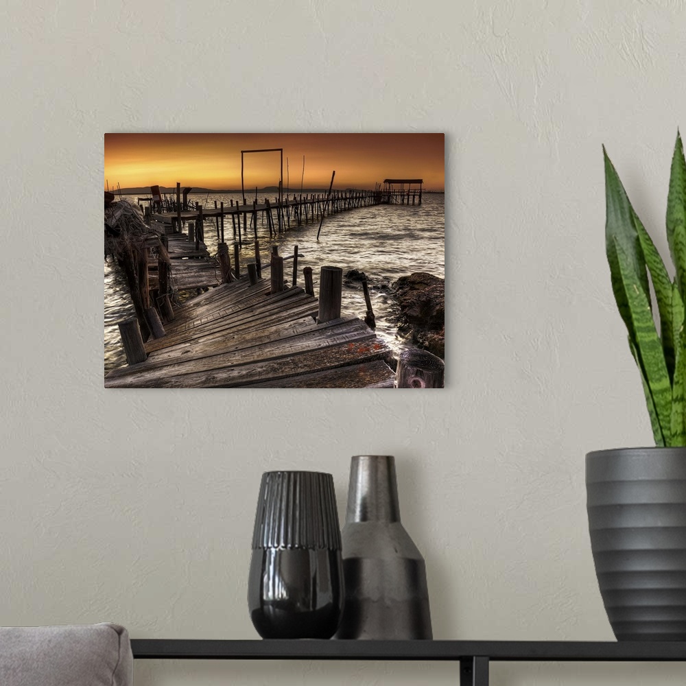 A modern room featuring A decaying wooden pier in Carrasqueira, Spain, at sunset.