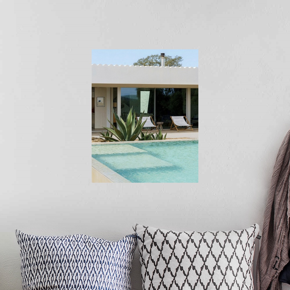 A bohemian room featuring A cool-toned photograph of an outdoor mediterranean swimming pool and villa