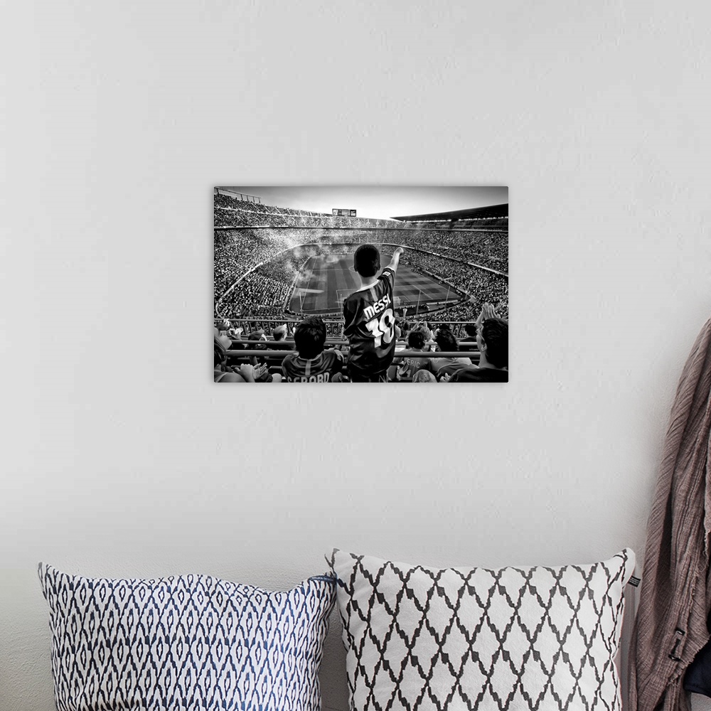 A bohemian room featuring A black and white photograph of a child standing up among thousands of seated people in a sports ...