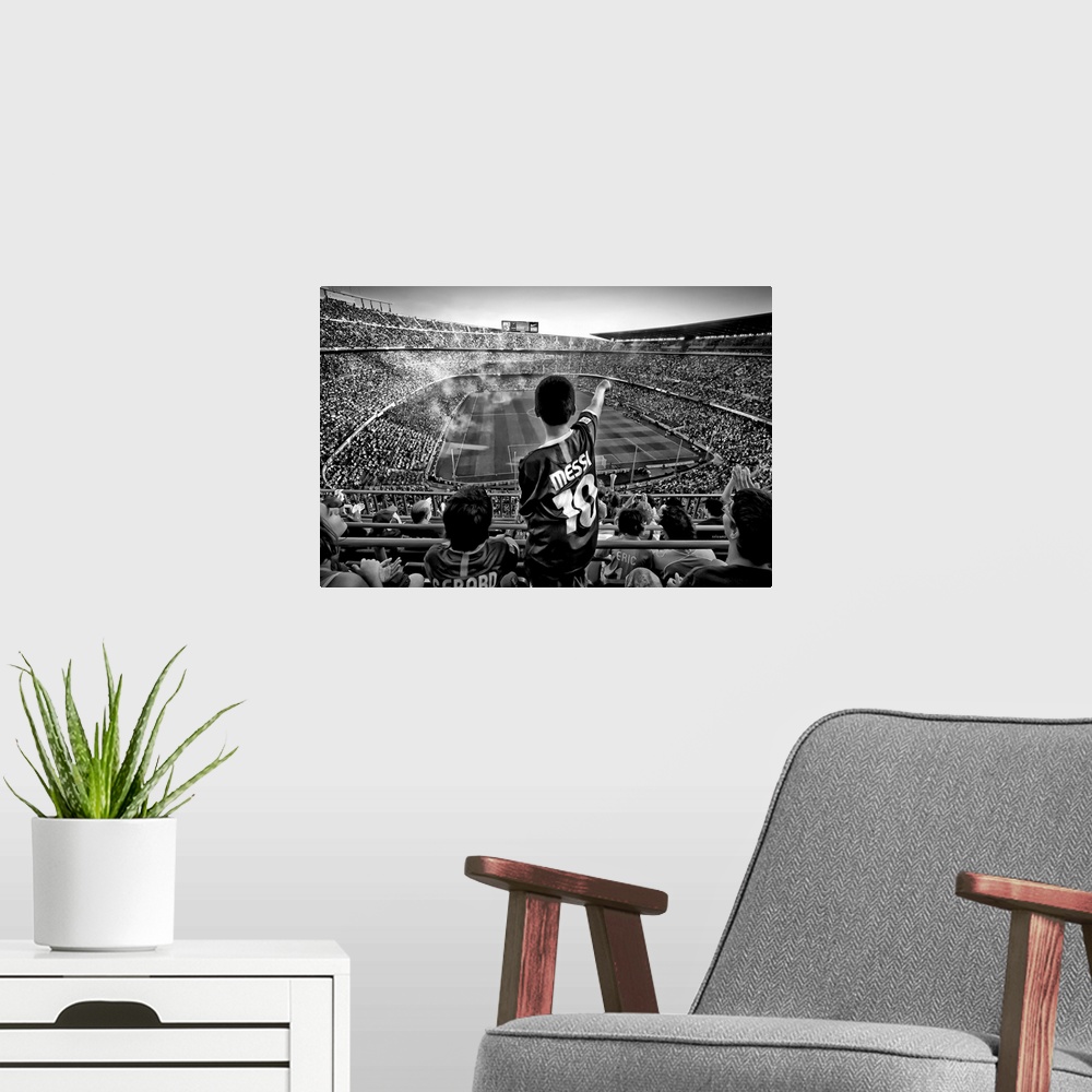 A modern room featuring A black and white photograph of a child standing up among thousands of seated people in a sports ...