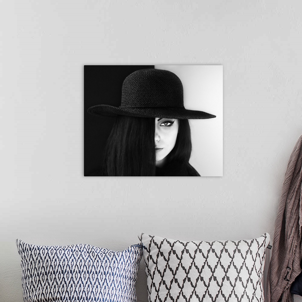 A bohemian room featuring Portrait of a woman with face half obscured, wearing a large hat.