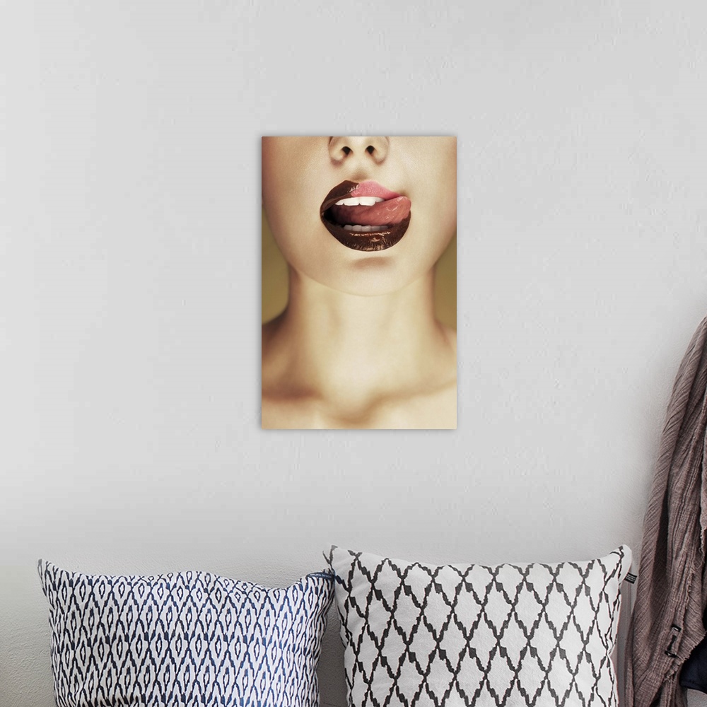 A bohemian room featuring A woman licking chocolate off of her lips with her tongue.