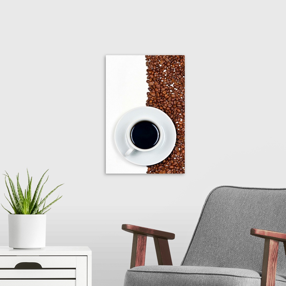 A modern room featuring Coffee in white cup on saucer placed on background of coffee beans and white.