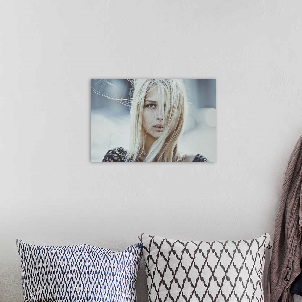 A bohemian room featuring Portrait of a blond woman with her hair blowing in the wind, obscuring her face.