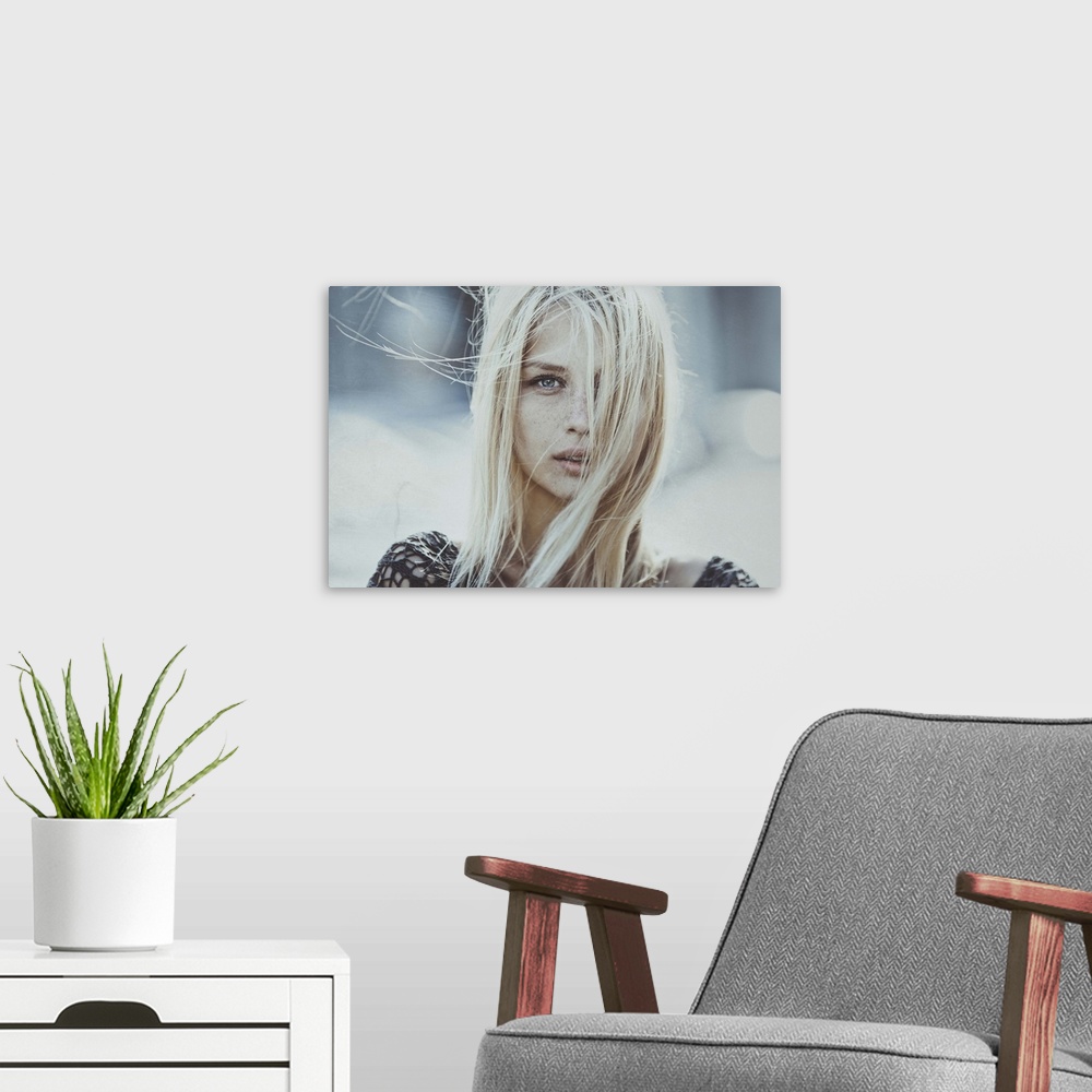 A modern room featuring Portrait of a blond woman with her hair blowing in the wind, obscuring her face.