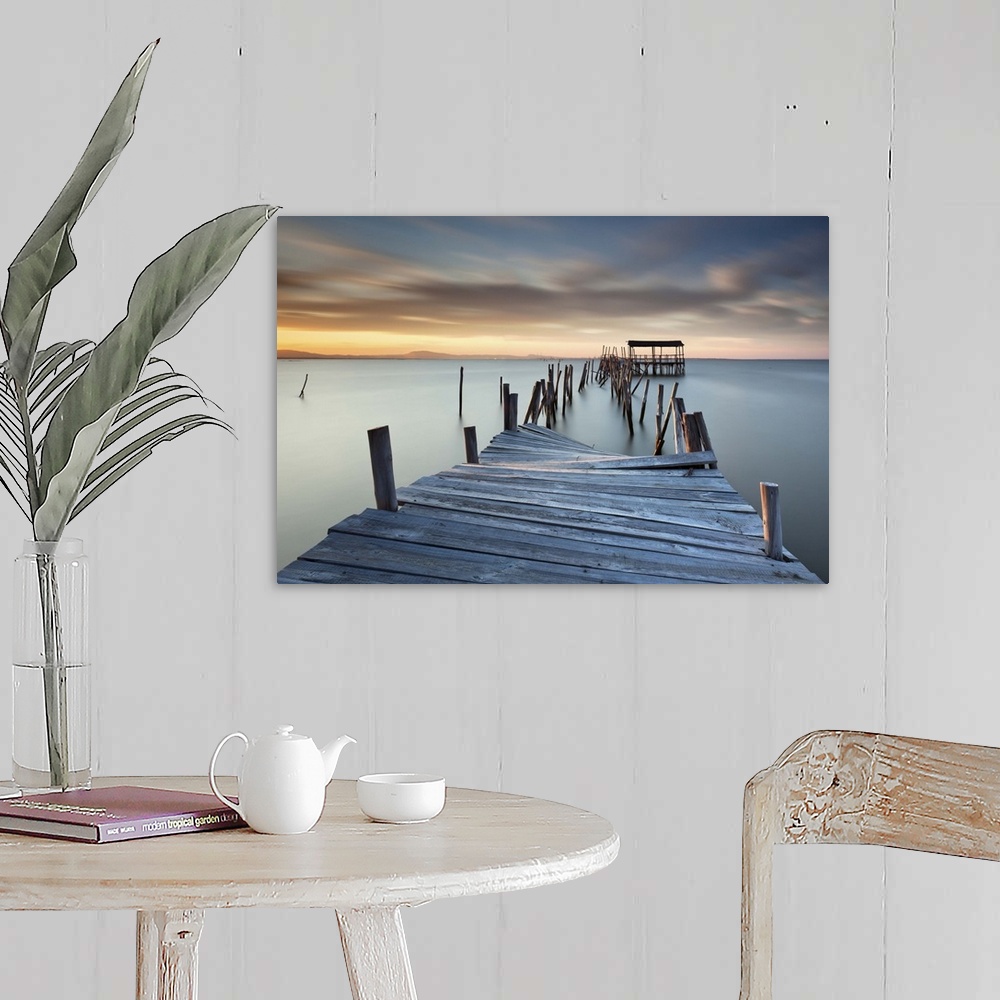 A farmhouse room featuring A broken wooden pier off the coast of Carrasqueira, Portugal, at sunset.