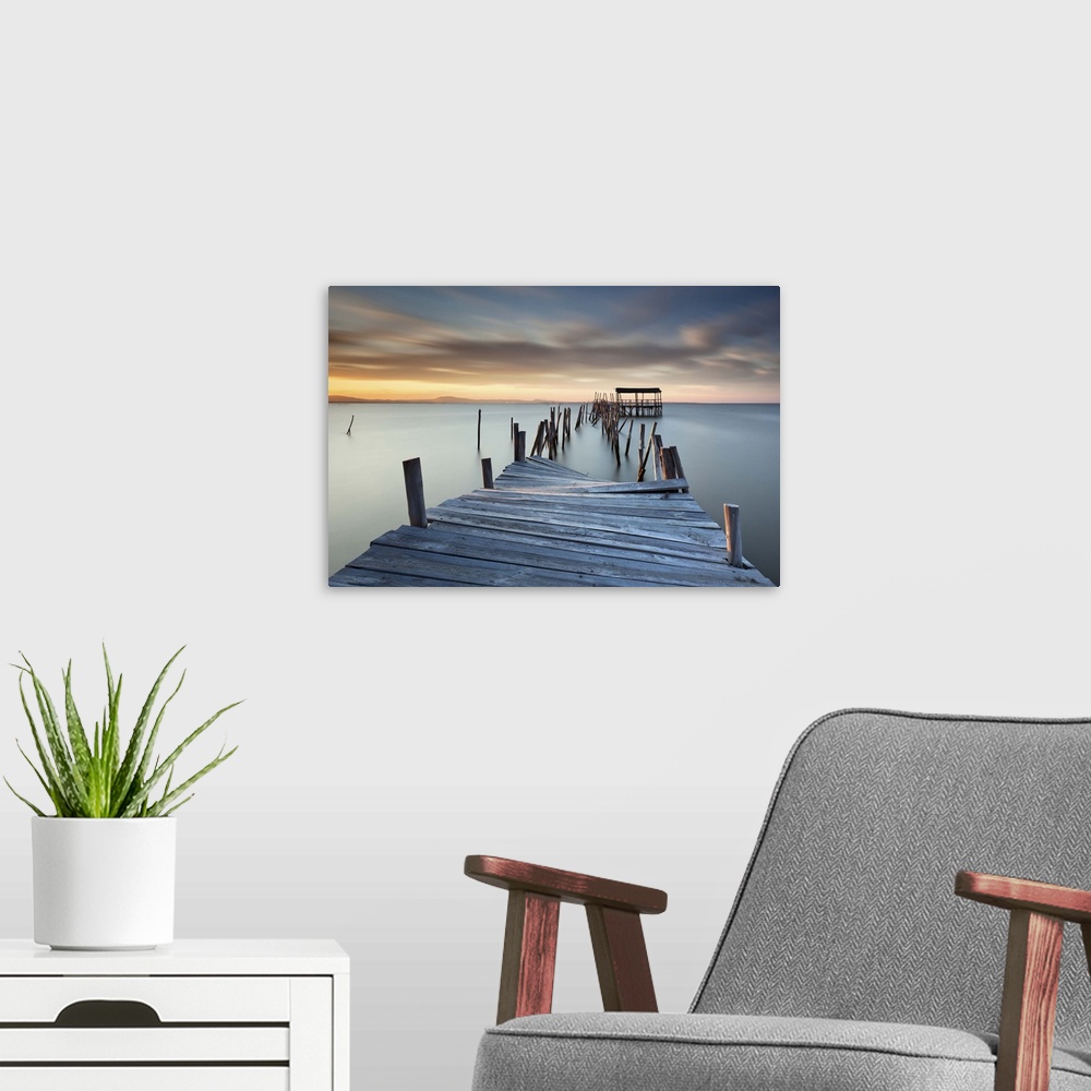 A modern room featuring A broken wooden pier off the coast of Carrasqueira, Portugal, at sunset.