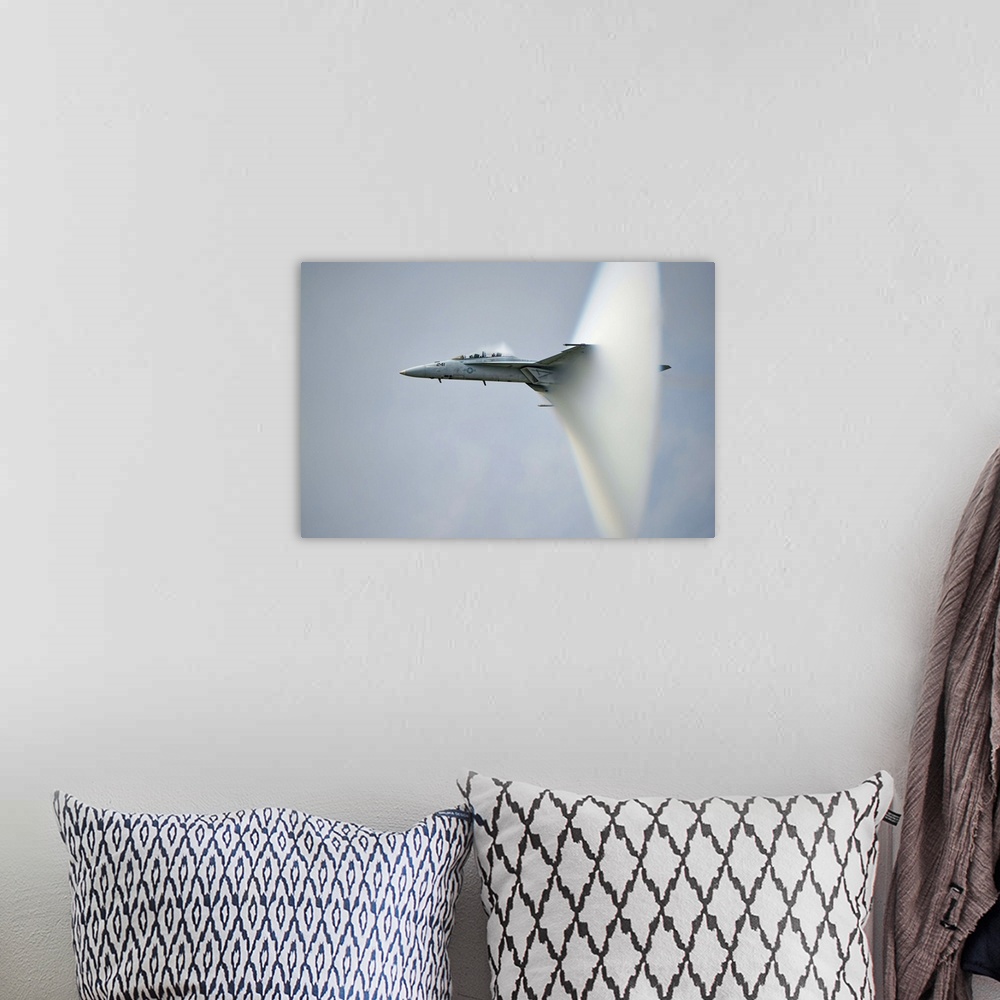 A bohemian room featuring A F/A-18 Super Hornet forming a cone of air as it breaks the sound barrier.