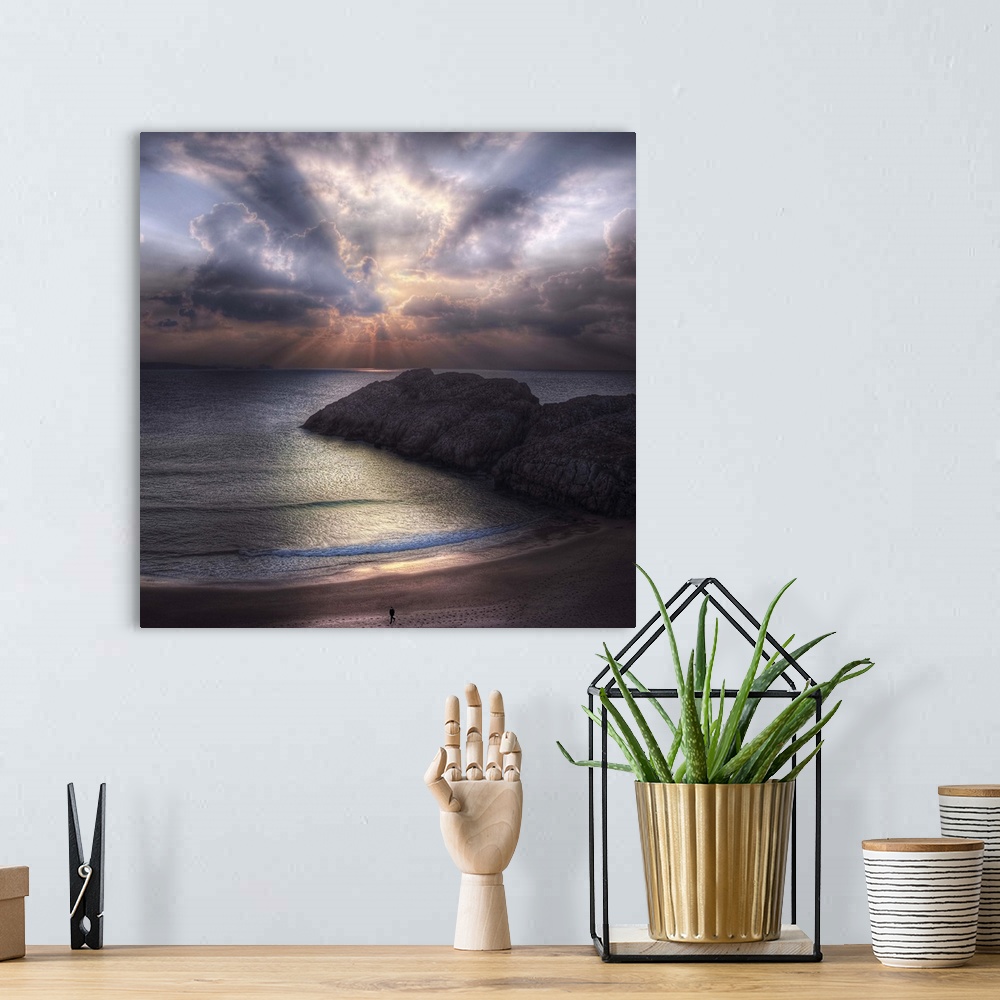 A bohemian room featuring Seascape with a figure walking along the  beach and rock formations in the ocean, during sunset w...