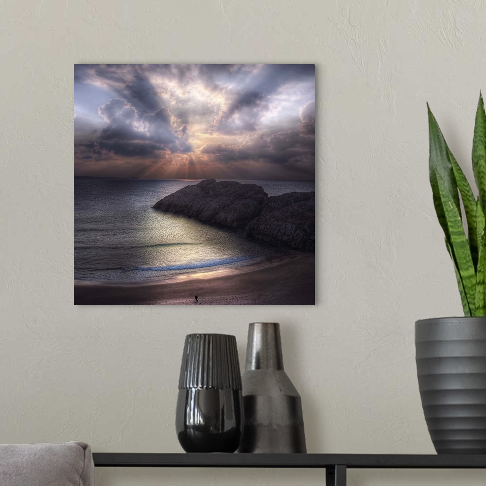 A modern room featuring Seascape with a figure walking along the  beach and rock formations in the ocean, during sunset w...
