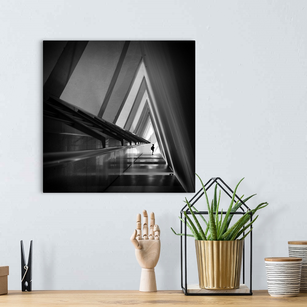 A bohemian room featuring A triangular-shaped hallway in shadows with sharp corners creates an abstract image.