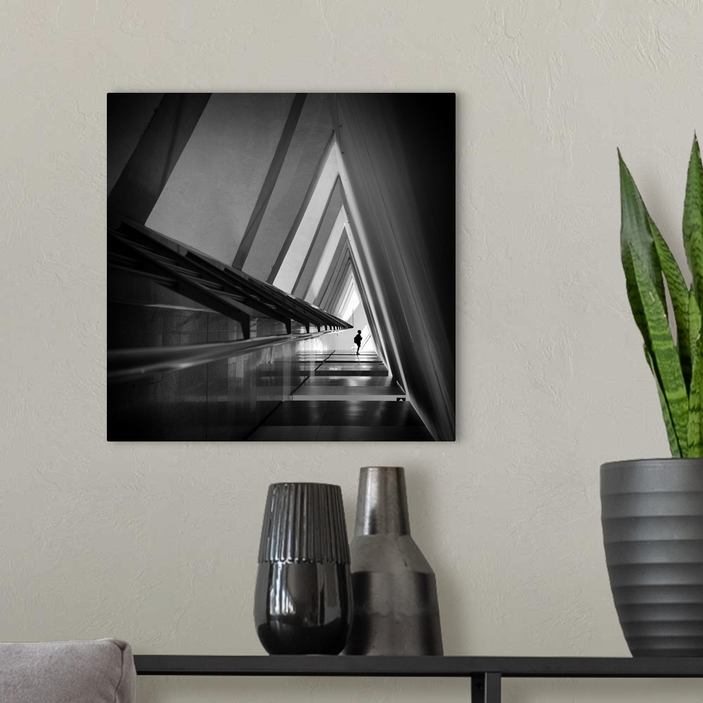 A modern room featuring A triangular-shaped hallway in shadows with sharp corners creates an abstract image.