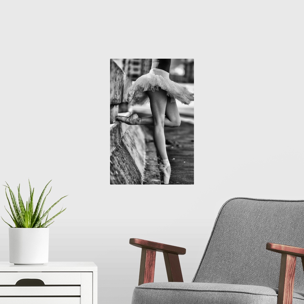 A modern room featuring A black and white photograph of a ballerina in a dancers pose leaning against a road divider outd...