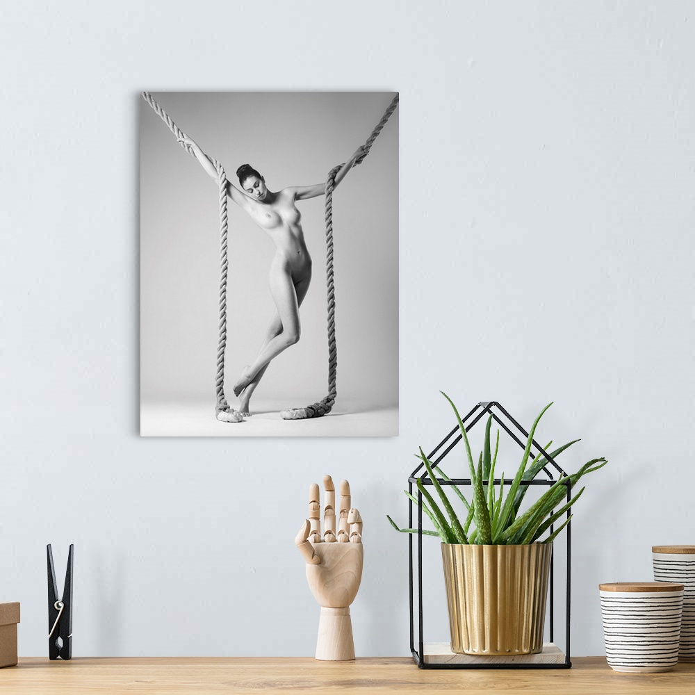 A bohemian room featuring Black and white fine art photograph of a nude woman intertwined with two large ropes.