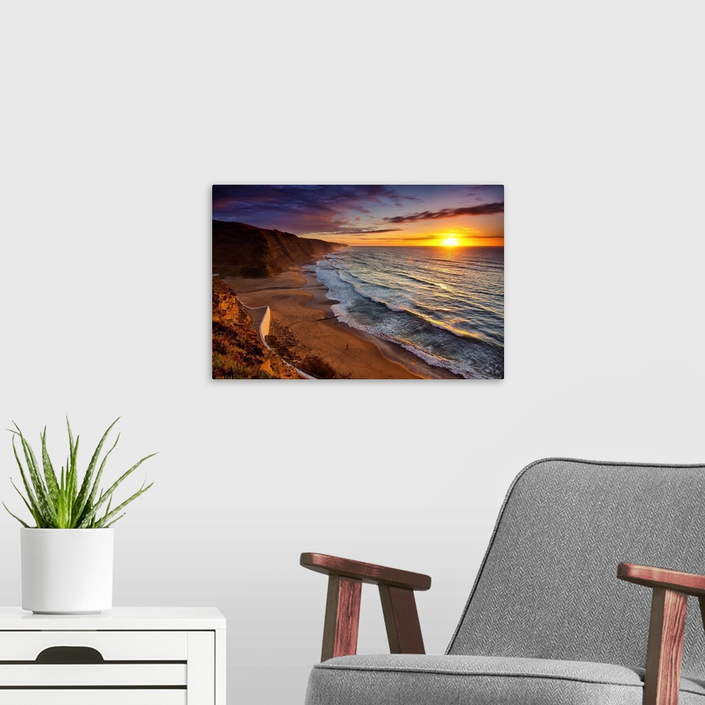 A modern room featuring Warm landscape photograph of the sunset in Praia Do Magoito, Portugal.