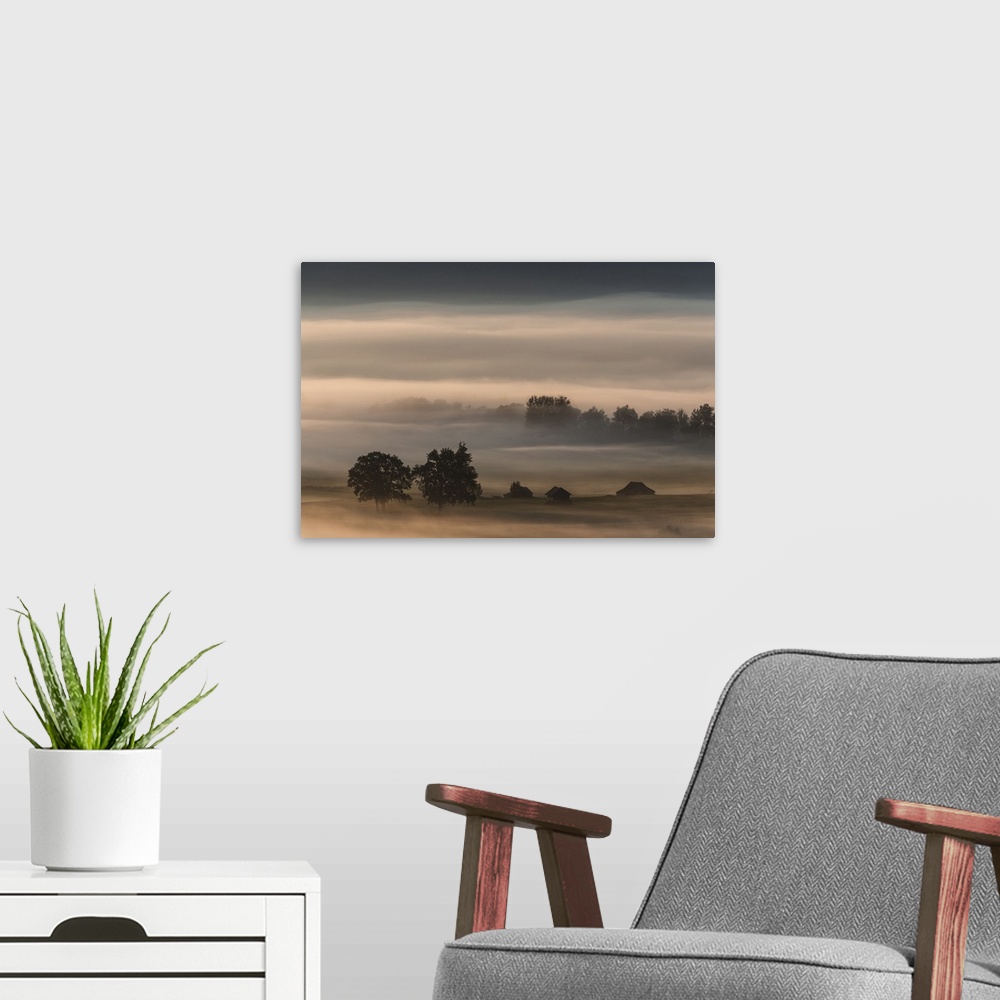 A modern room featuring Landscape photograph of dense fog over farmland.