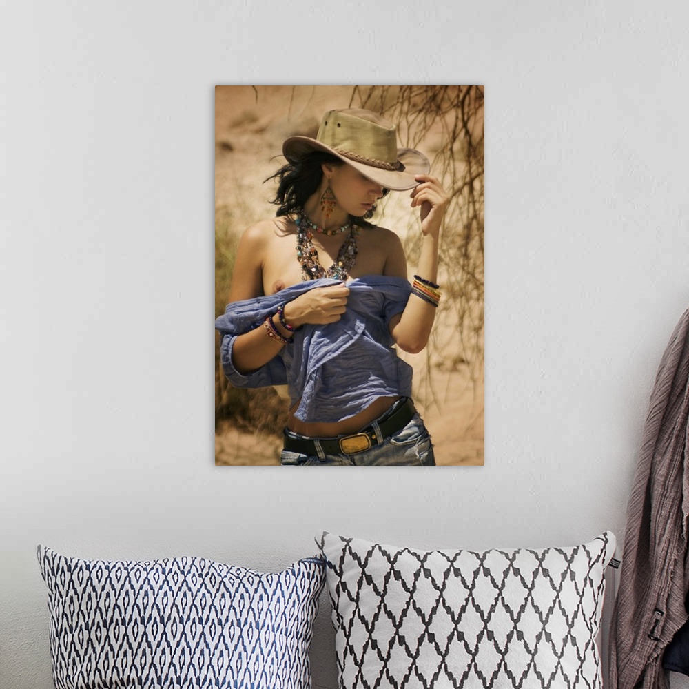A bohemian room featuring A model with a cowboy hat and beaded jewelry walking in the desert.
