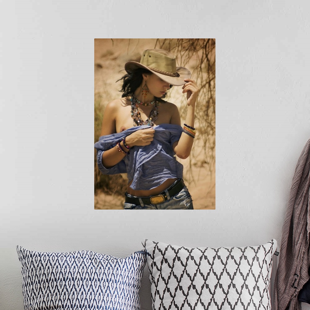 A bohemian room featuring A model with a cowboy hat and beaded jewelry walking in the desert.