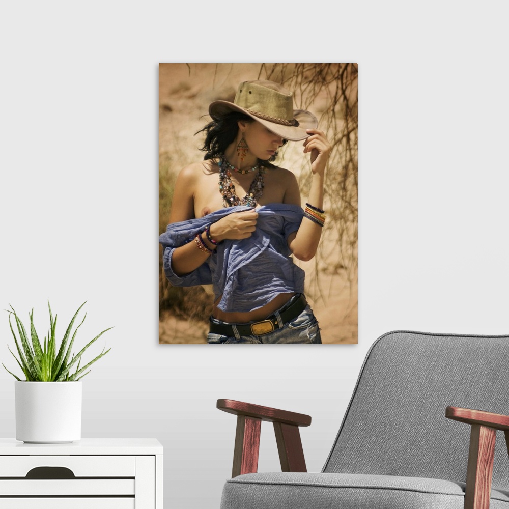 A modern room featuring A model with a cowboy hat and beaded jewelry walking in the desert.
