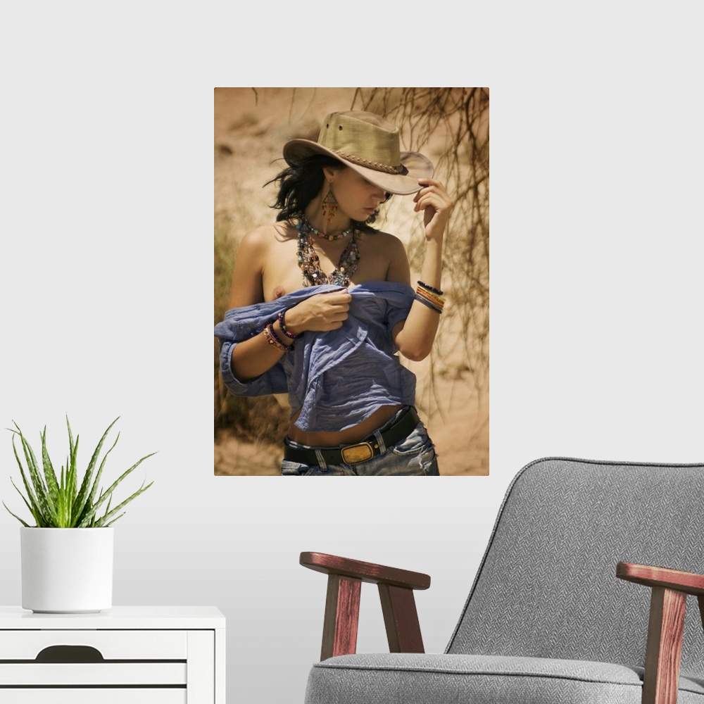 A modern room featuring A model with a cowboy hat and beaded jewelry walking in the desert.