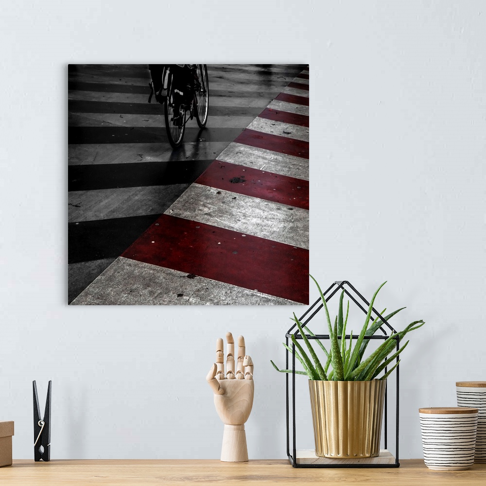 A bohemian room featuring A bicycle on the street with red and white stripes painted on the road.