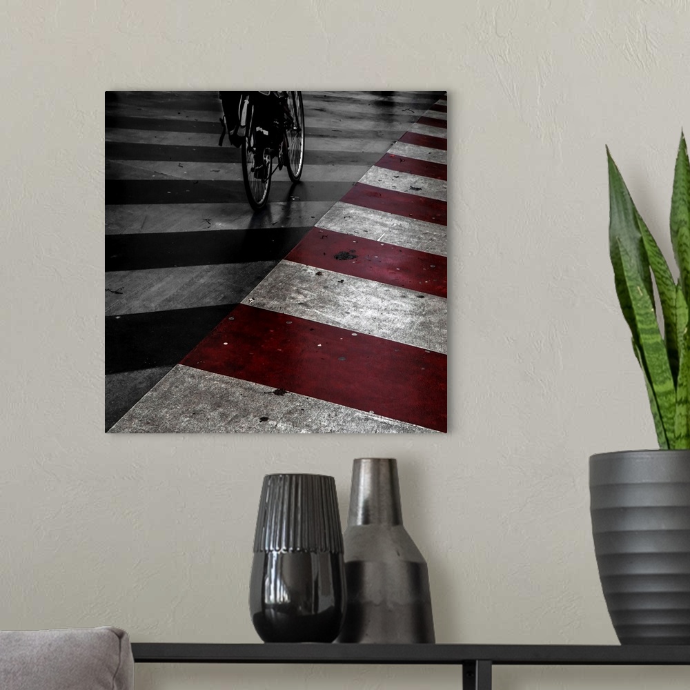 A modern room featuring A bicycle on the street with red and white stripes painted on the road.