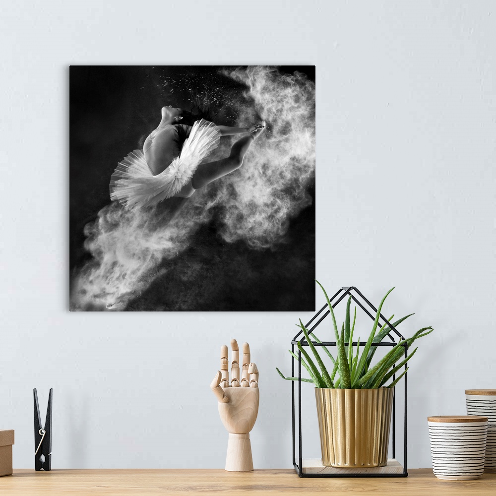 A bohemian room featuring A black and white photograph of a dancer leaping into the air with dust kicking off her hands and...