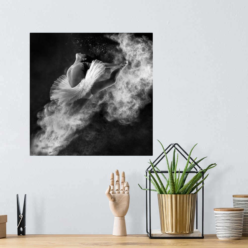 A bohemian room featuring A black and white photograph of a dancer leaping into the air with dust kicking off her hands and...