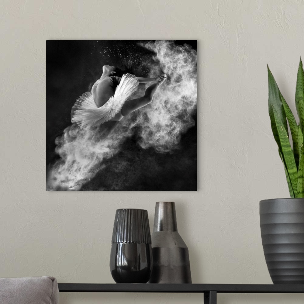 A modern room featuring A black and white photograph of a dancer leaping into the air with dust kicking off her hands and...