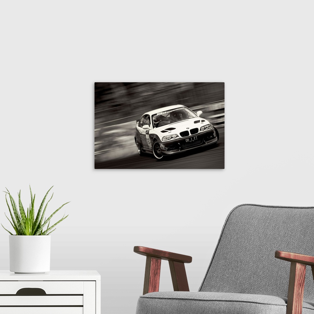 A modern room featuring A black and white photograph of a sports car drifting against a blurred background.
