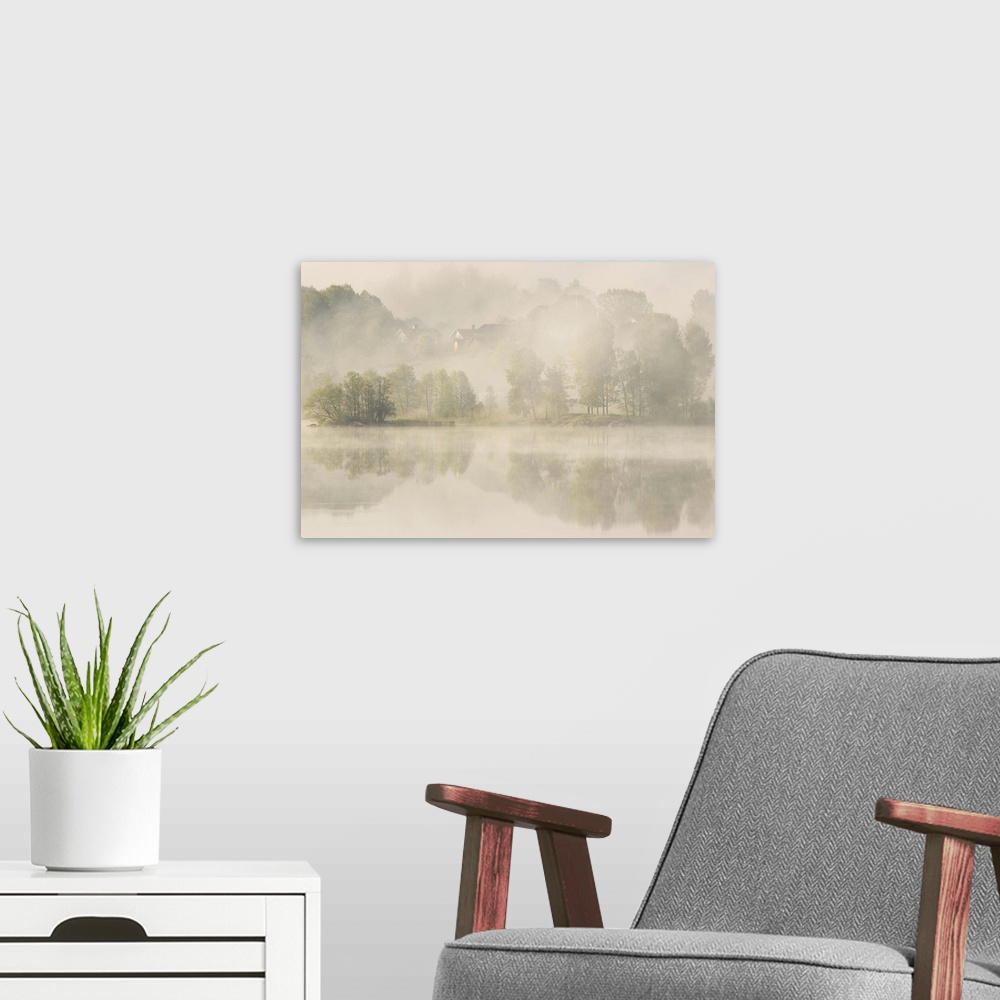 A modern room featuring Heavy fog over a lake with houses on the shore, Sweden.