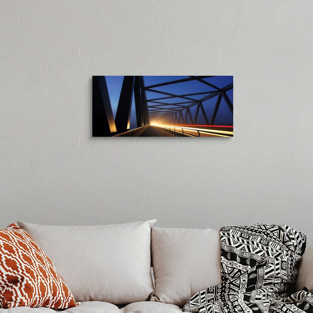 A bohemian room featuring Light trails on a bridge with cross beams forming simple shapes in the morning.