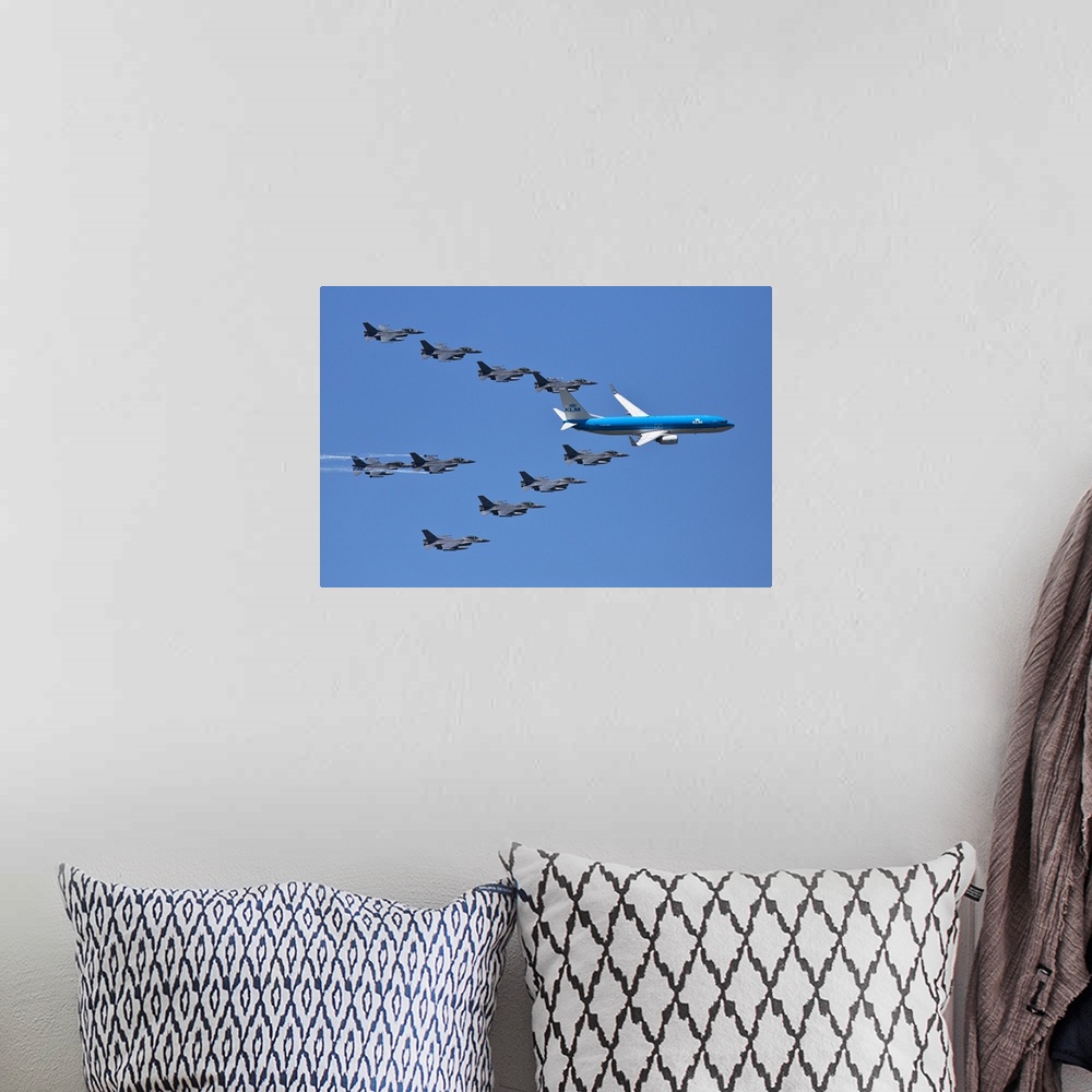A bohemian room featuring A fleet of grey jets fly in formation around a blue commercial airliner.