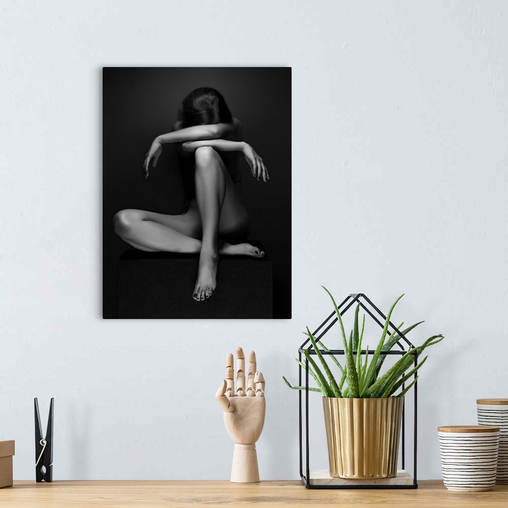 A bohemian room featuring Black and white fine art photograph of a woman sitting down, creating angles with her body, resem...