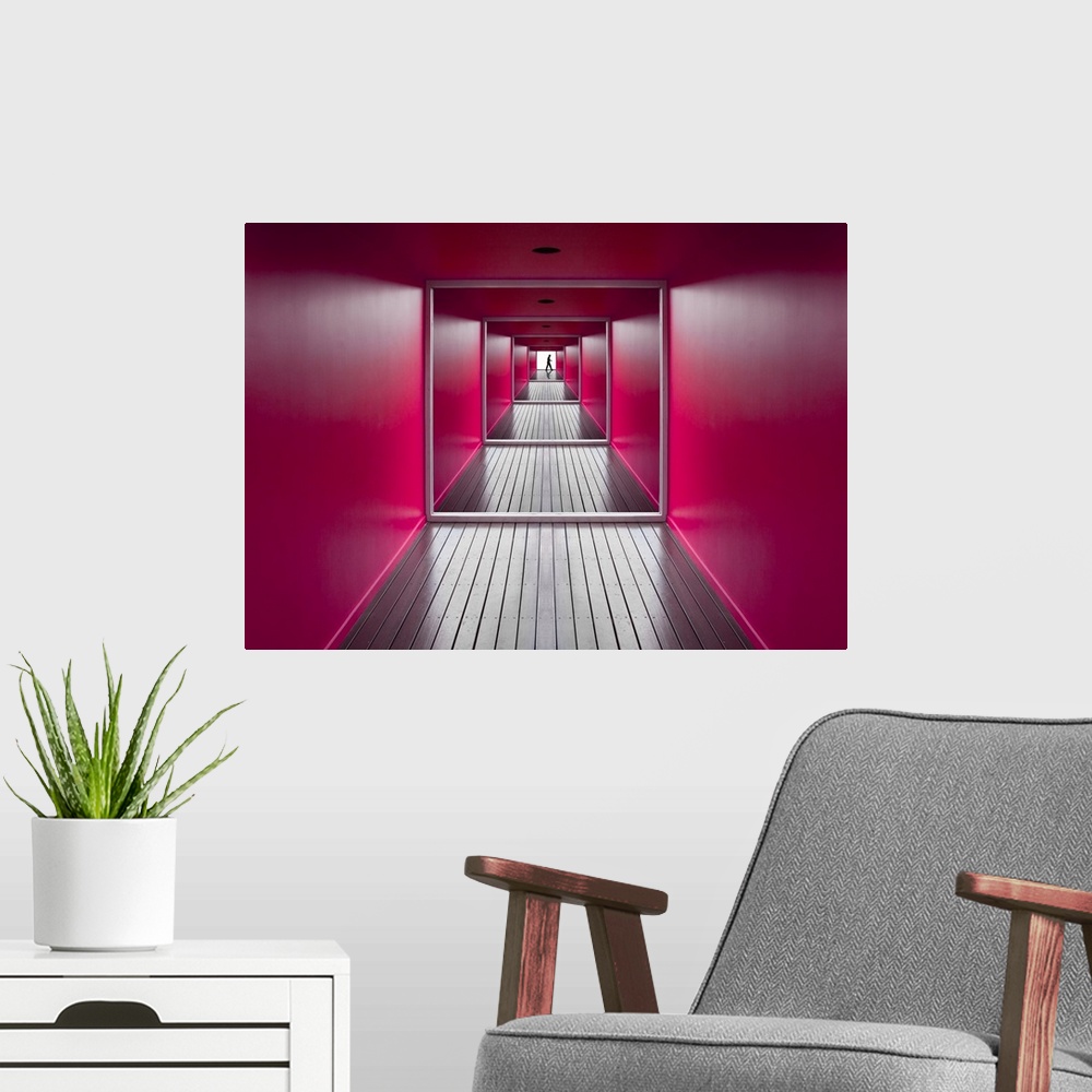 A modern room featuring A square shaped hallway with bright pink walls, and a figure at the exit.