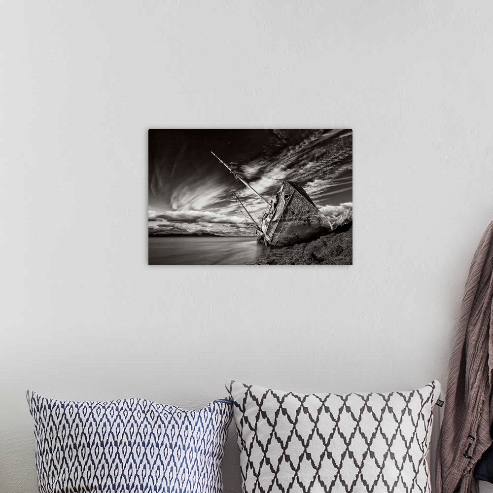 A bohemian room featuring A black and white photograph of a derelict ship washed up on the shores of Iceland.