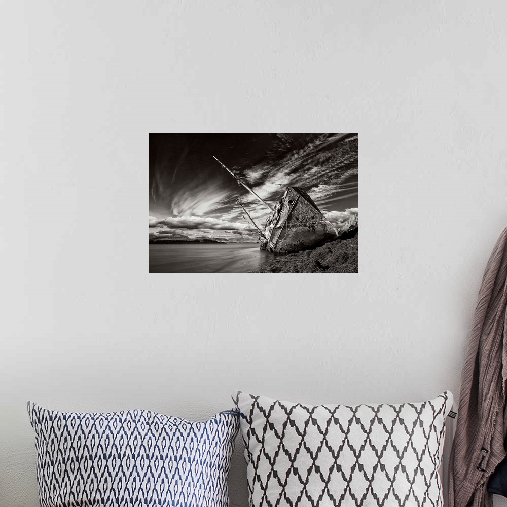 A bohemian room featuring A black and white photograph of a derelict ship washed up on the shores of Iceland.