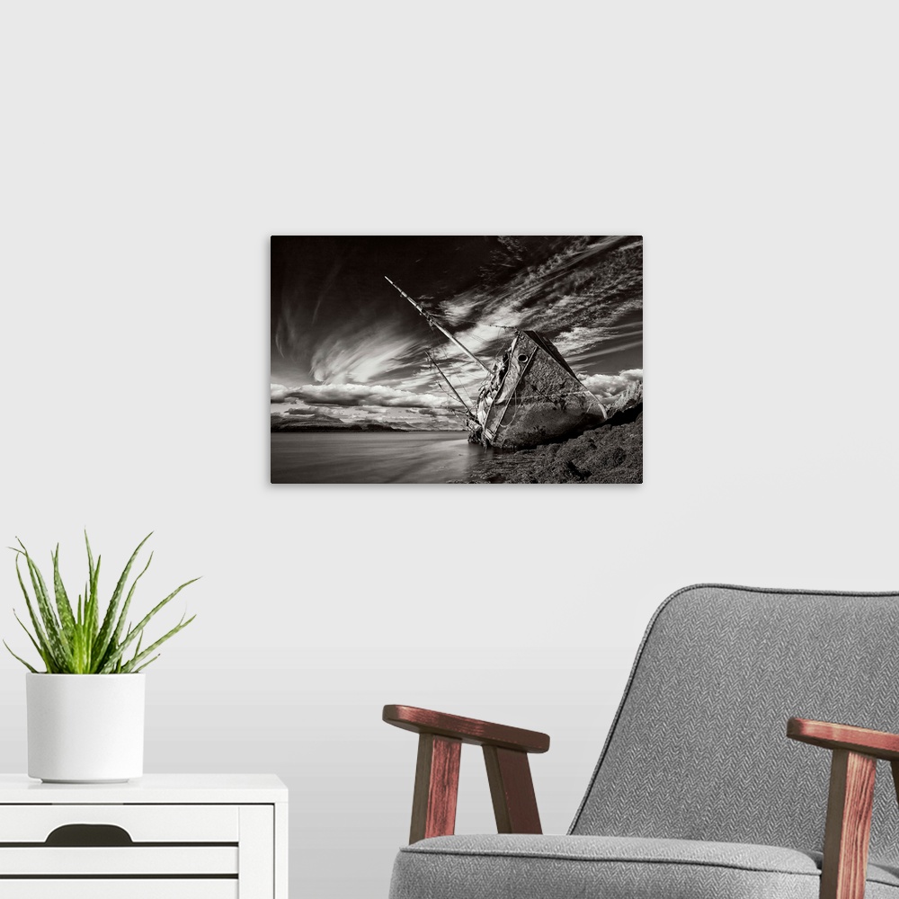 A modern room featuring A black and white photograph of a derelict ship washed up on the shores of Iceland.